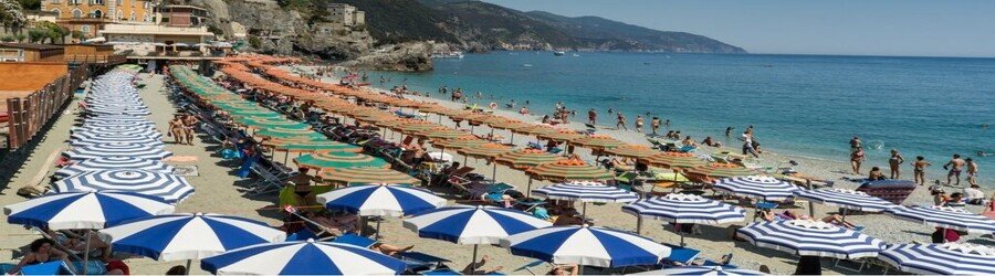 Monterosso al Mare beach with umbrellas and clear water on the Ligurian coast