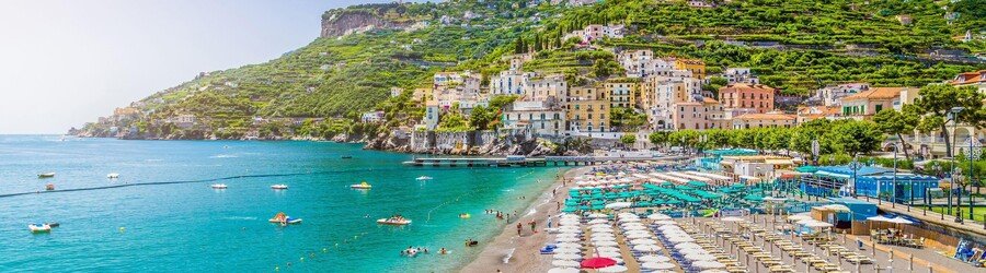 Salerno beachfront with colorful buildings and umbrellas along the coast