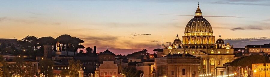 St Peters Basilica in Rome at sunset with glowing dome and city skyline