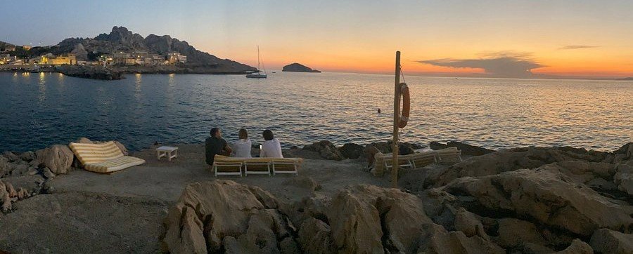 Tuba Club seaside sunset in Les Goudes Marseille with rocky coast, ocean view, and relaxed beach setting.