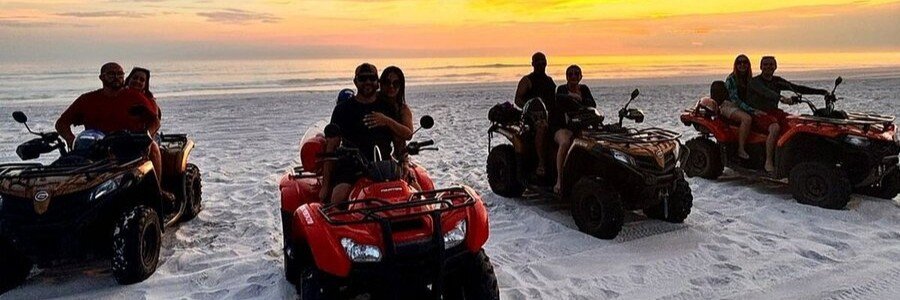 People riding ATVs on the sand at sunset in Arraial do Cabo, Brazil