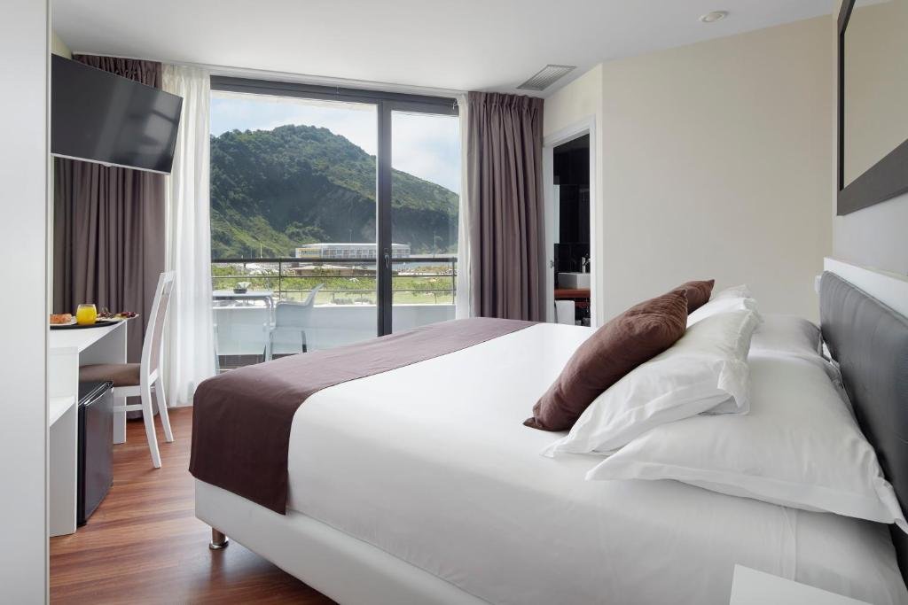 Modern guest room at Hotel & Thalasso Villa Antilla with balcony and mountain view