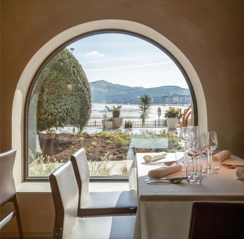Elegant dining area at Hotel Ur Bare with arched window and ocean view