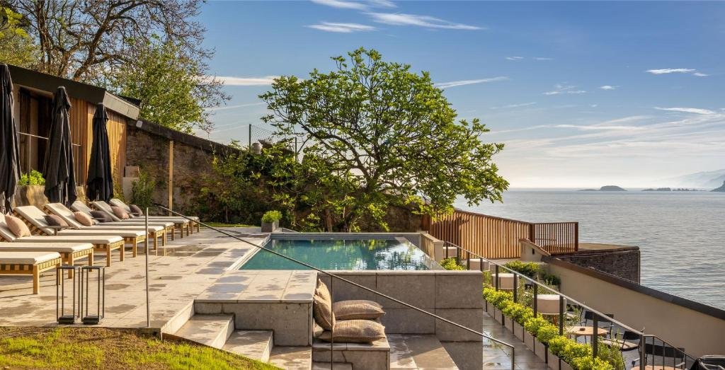 Luxury pool area at Hotel Ur Bare overlooking the sea with lounge chairs