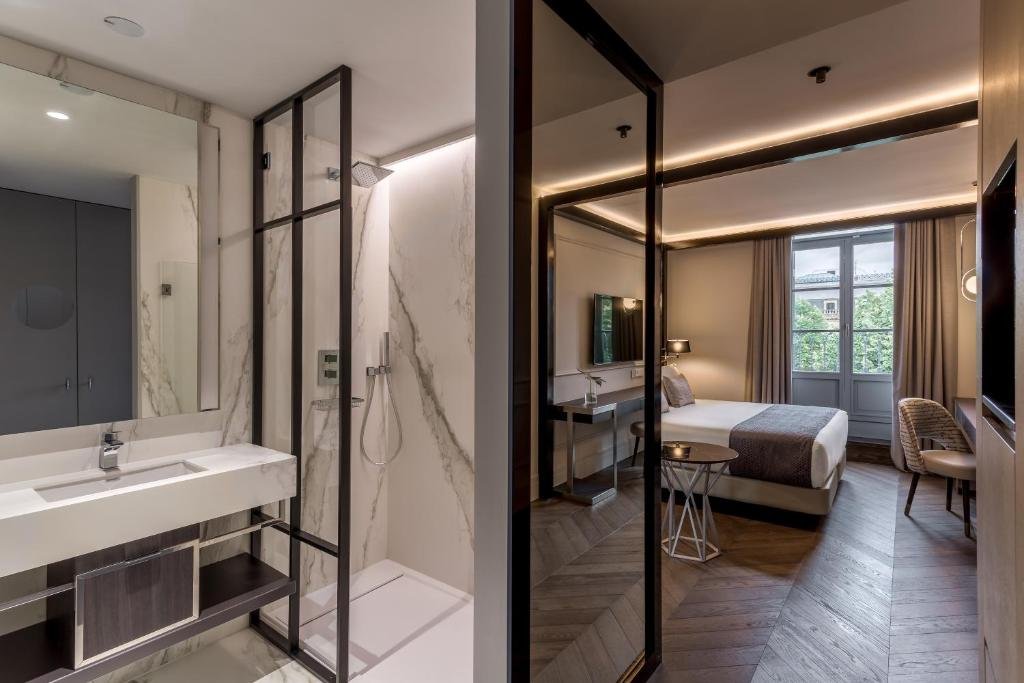 Modern guest suite at Room Mate Collection Gorka with sleek bathroom and bedroom