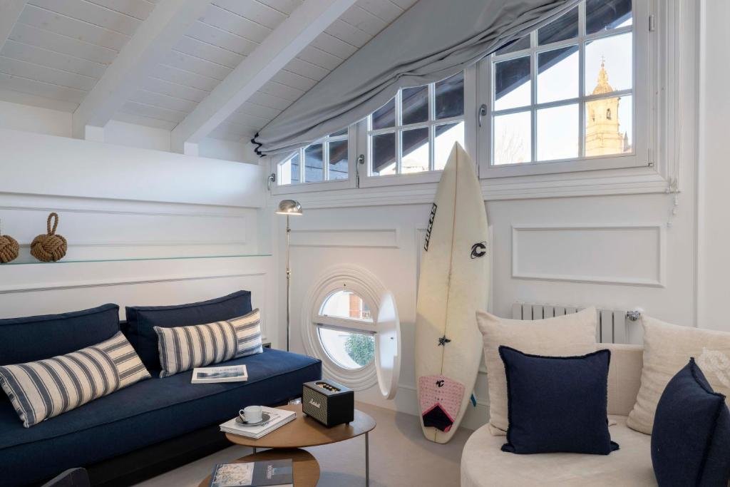 Cozy living space at Villa Magalean Hotel with sofa, surfboard, and natural light