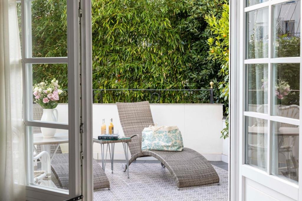 Private terrace at Villa Magalean Hotel with lounge chair and garden views