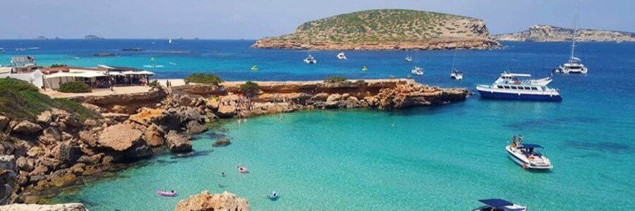 Crystal clear turquoise waters and offshore rocky islands at Cala Comte Platges de Comte in Ibiza