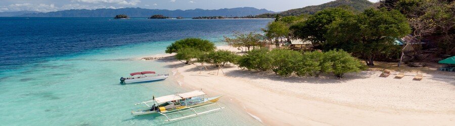 Malcapuya Island Beach Coron with powdery white sand and boats