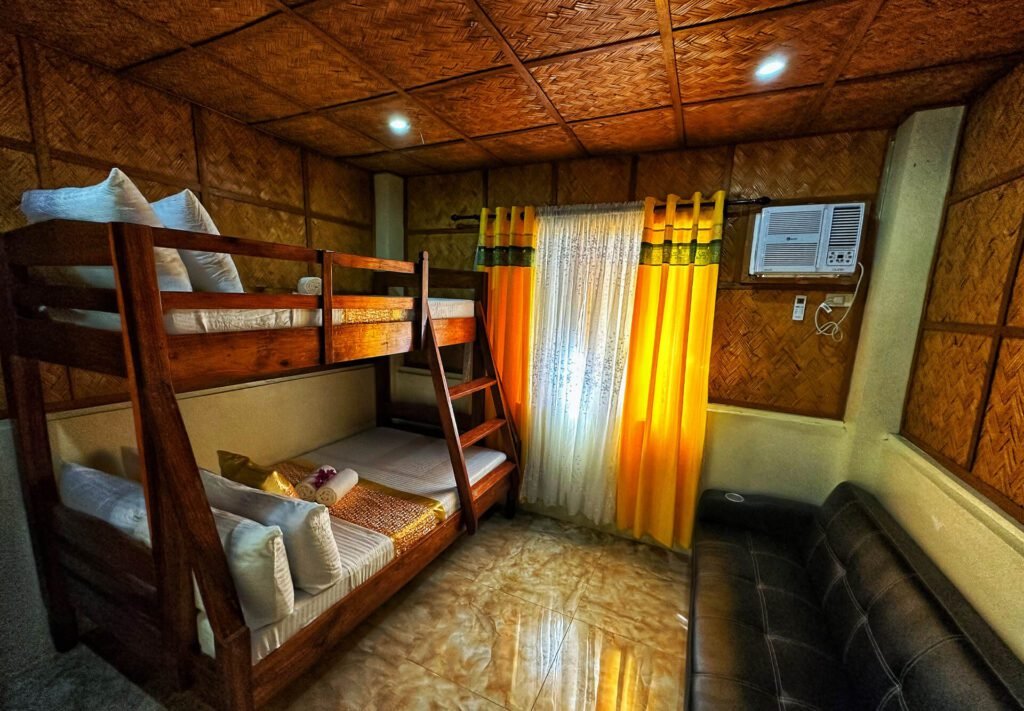Interior of a cottage at Rock Island Eres Bella with wooden bunk beds and woven walls