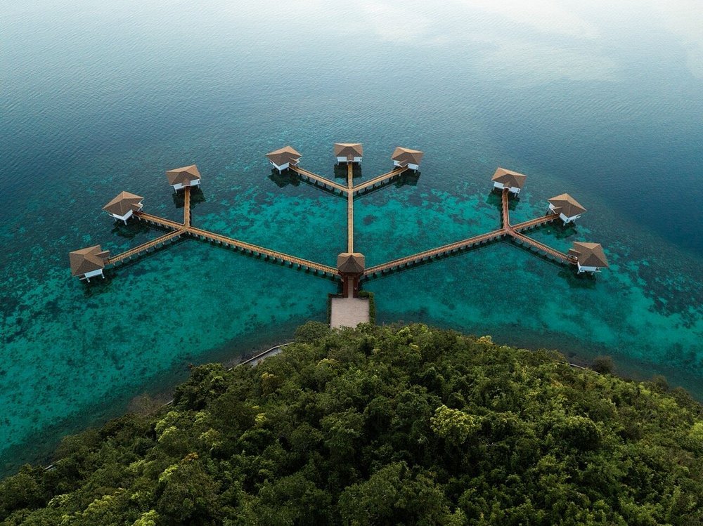 Sunlight Ecotourism Island Resort overwater villas above clear turquoise water