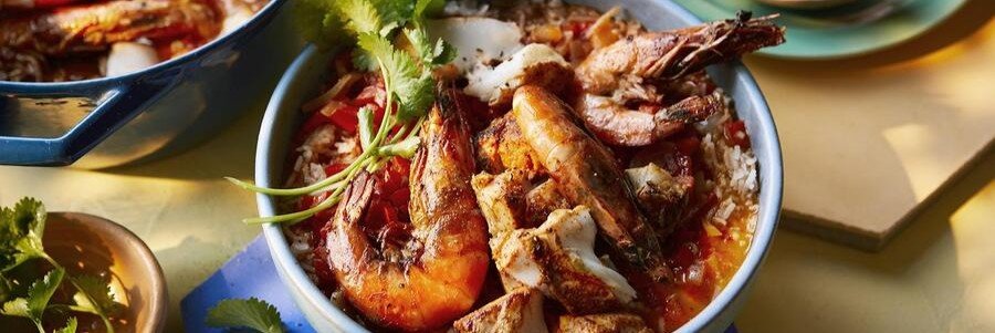 Brazilian Seafood Moqueca in Búzios Brazilian seafood moqueca served with shrimp, fish, rice, tomatoes, peppers, and fresh herbs.