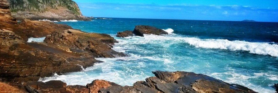 Atlantic Waves Along the Rocky Búzios Coast Powerful Atlantic waves breaking over dark coastal rocks on the ocean-facing side of Búzios, Brazil.