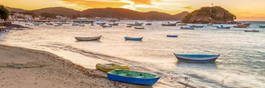 Sunset Over the Harbor in Búzios | Beach Travel Destinations Fishing boats floating in the harbor during sunset in Búzios, Brazil.