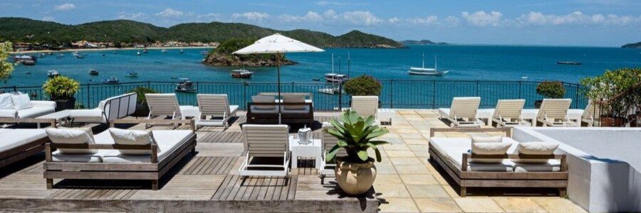 Casas Brancas Boutique Hotel & Spa Bay Terrace Sea-view terrace with loungers and outdoor seating at Casas Brancas Boutique Hotel & Spa in Búzios, Brazil.