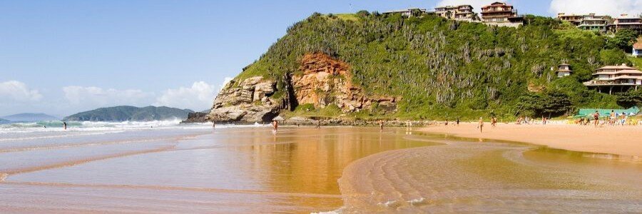 Geribá Beach Surfing and Golden Shoreline Wide golden shoreline, Atlantic waves, green cliffs, and beachgoers at Geribá Beach in Búzios, Brazil.