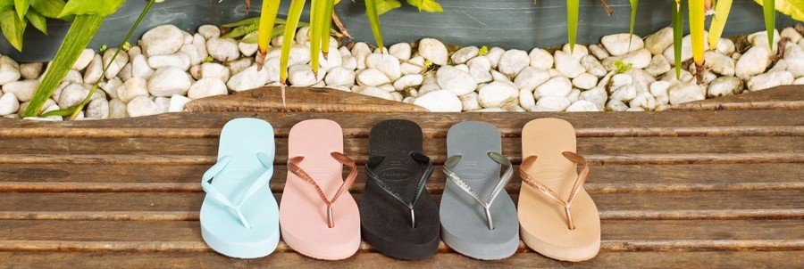 Havaianas flip flops lined up on a wooden bench with tropical plants in Rio de Janeiro Brazil beach lifestyle