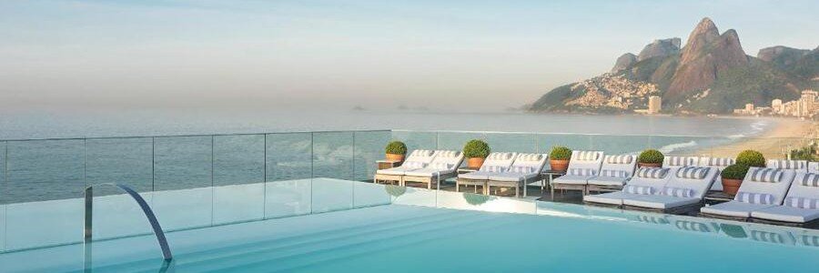 Rooftop infinity pool at Hotel Fasano overlooking Ipanema Beach and the Dois Irmaos mountains in Rio de Janeiro.