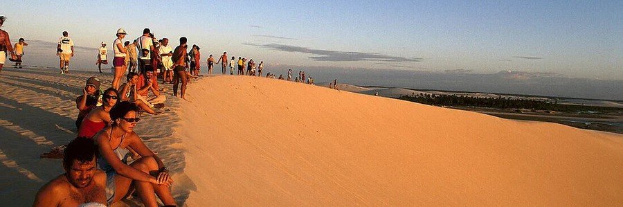 Visitors gathered on a sand dune watching the sunset in Jericoacoara National Park, Brazil.