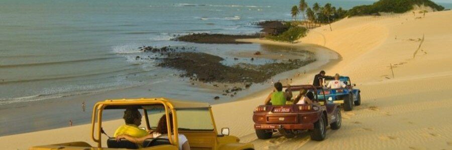 Buggy tour driving across sand dunes and beaches near Praia da Pipa, Brazil.