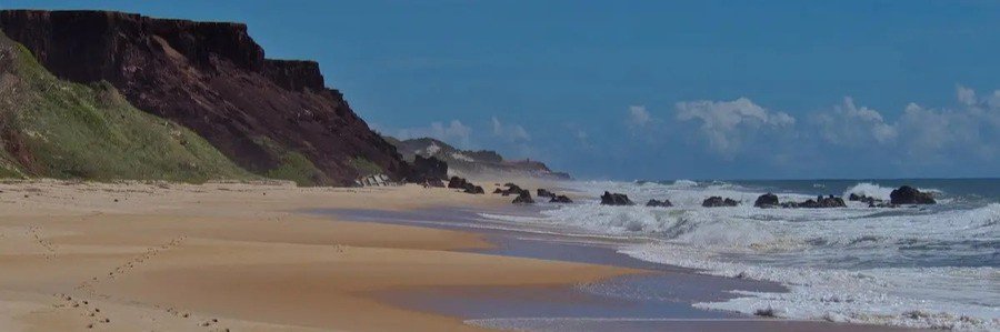 Praia das Minas with dramatic sea cliffs and a quiet sandy beach near Praia da Pipa, Brazil.