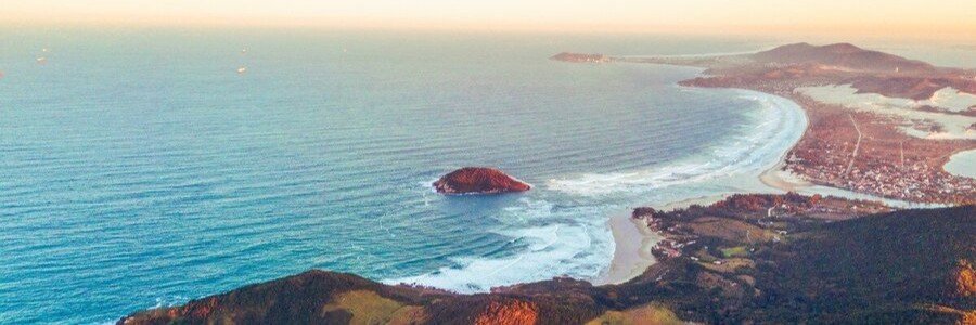 Aerial view of Praia do Rosa's sweeping coastline, beaches, and Atlantic Ocean in Brazil.
