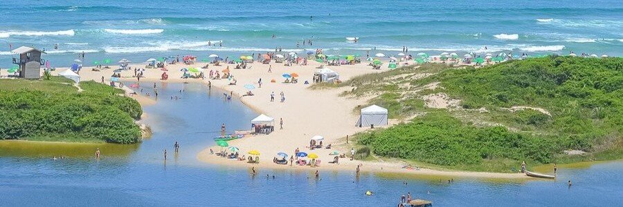 Aerial view of a coastal lagoon flowing into the ocean at Praia do Rosa, Brazil.