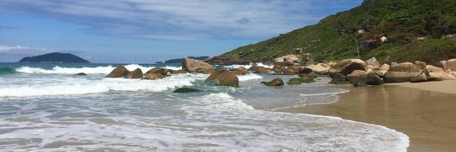 Praia do Saquinho Beach Florianopolis | Beach Travel Destinations Waves rolling onto the sandy shoreline at Praia do Saquinho in Florianópolis.