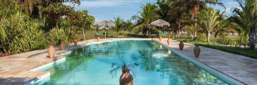 Large tropical swimming pool surrounded by palm trees at Rancho do Peixe near Jericoacoara.