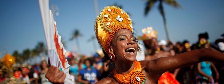 Carnival dancer performing during a Rio de Janeiro street parade with colorful costume and festive crowd