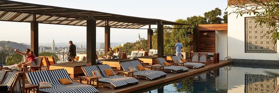 The tropical hillside pool deck with striped lounge chairs at Santa Teresa Hotel RJ MGallery in Rio de Janeiro