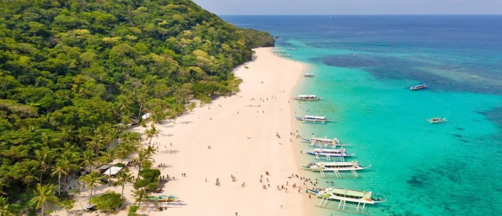 Aerial view of a white sand beach with turquoise water in the Philippines