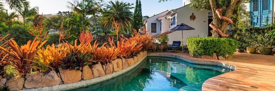 Vila da Santa Hotel Boutique & Spa Garden Pool Curved swimming pool surrounded by colorful tropical gardens at Vila da Santa Hotel Boutique & Spa in Búzios.