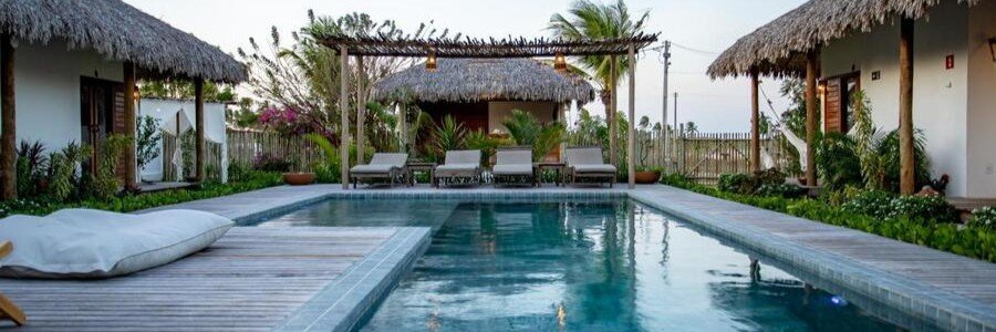 Swimming pool surrounded by tropical bungalows at Vilarejo Preá near Jericoacoara.