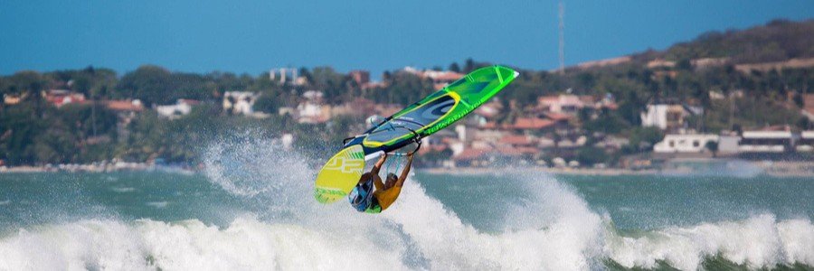 Windsurfer performing an aerial jump on the waves in Jericoacoara, Brazil.