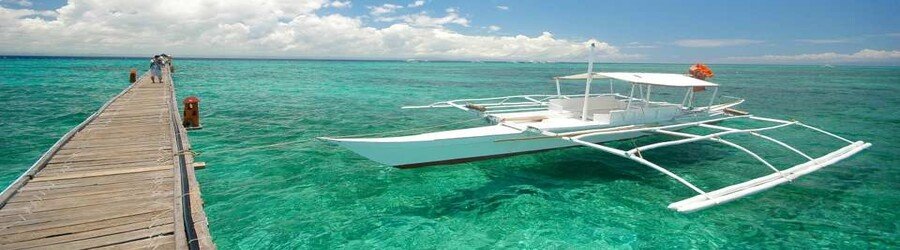 Island hopping tour in Mactan Cebu with boat docked over clear turquoise water
