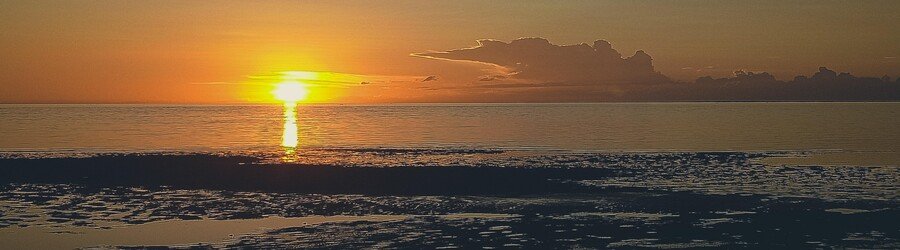 Sunset at San Remigio Cebu with golden sky and calm ocean waves