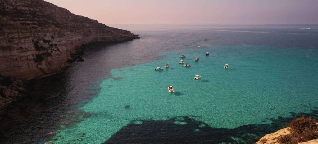 Cala Tabaccara in Lampedusa with clear turquoise water and boats