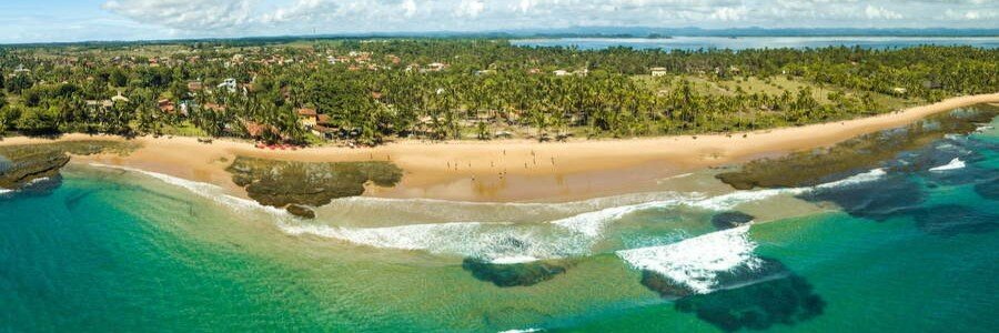 Aerial view of the Maraú Peninsula coastline with coral reefs, turquoise water, and tropical vegetation.