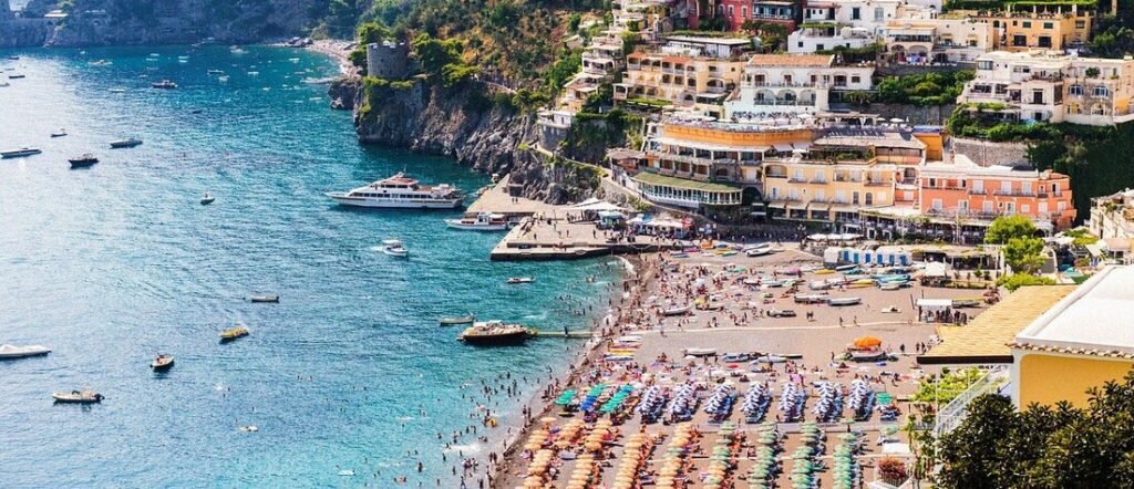 Positano Italy beach and colorful cliffside buildings along the Amalfi Coast