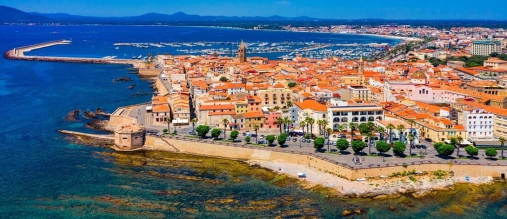 Sardinia coastal town with historic center, marina, and deep blue sea