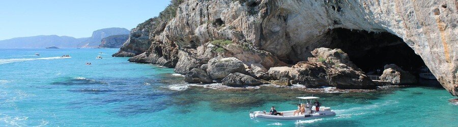 small boat near sea cave in Sardinia