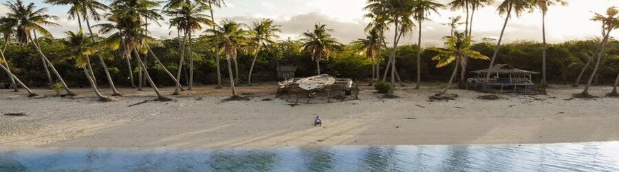 Palm-lined Paliton Beach in Siquijor, Philippines, with white sand, calm water, and a peaceful tropical setting