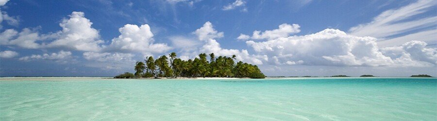 Shallow crystal-blue water and coconut islet at the Blue Lagoon in Rangiroa