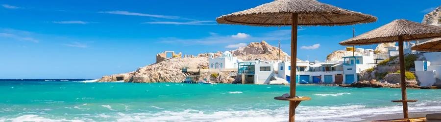 Traditional fishing village in Milos, Greece with whitewashed houses and blue sea views.