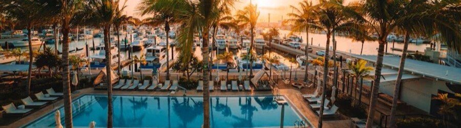 Luxury marina pool at The Perry Hotel & Marina in Key West surrounded by palm trees and waterfront views.