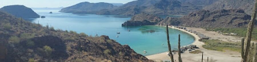 Scenic view of Bahía Concepción coastline near Mulegé, Mexico, with calm blue water, sandy beaches, and desert mountains in the background