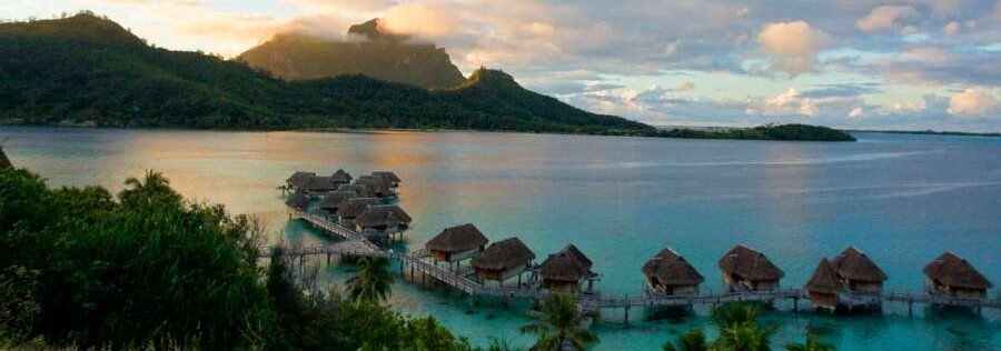 Overwater bungalows in Bora Bora at sunset with mountain and lagoon view
