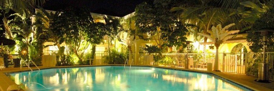 The Caribbean Court Boutique Hotel | Beach Travel Destinations The illuminated swimming pool surrounded by tropical gardens at The Caribbean Court Boutique Hotel in Vero Beach.