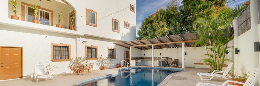 casa-de-la-mar-loreto-oceanfront-pool-view-stay | Beach Travel Destinations Oceanfront pool at Casa de La Mar in Loreto, Mexico with palm trees, lounge chairs, and a clear view of the Sea of Cortez stretching into the distance